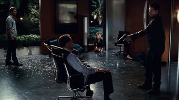 Movie still from “Trespass” (2011), directed by Joel Schumacher – A man sitting in a chair in a room; Wide shot, High angle