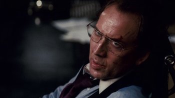 Movie still from “Trespass” (2011), directed by Joel Schumacher – A person wearing glasses and a tie; Close Up shot, Over the shoulder angle