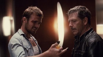 Movie still from “Trespass” (2011), directed by Joel Schumacher – Two men one is holding a knife and the other is holding a cell phone; Close Up shot, Over the shoulder angle