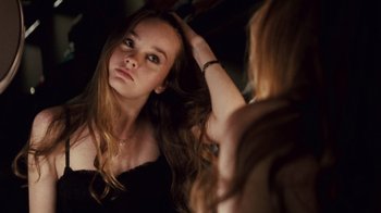 Movie still from “Trespass” (2011), directed by Joel Schumacher – A woman is looking into a mirror while holding her hair; Close Up shot, Over the shoulder angle