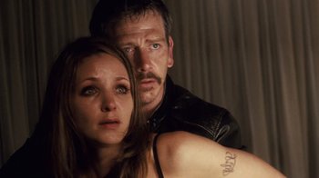 Movie still from “Trespass” (2011), directed by Joel Schumacher – A man and a woman are posing for a picture; Close Up shot, Low angle