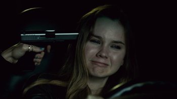 Movie still from “Trespass” (2011), directed by Joel Schumacher – A woman holding a gun while sitting in a car; Close Up shot, Over the shoulder angle