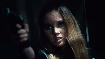 Movie still from “Trespass” (2011), directed by Joel Schumacher – A woman holding a gun in a dark room; Close Up shot, Low angle