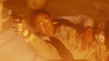 Movie still from “Trespass” (2011), directed by Joel Schumacher – An old man in a suit and tie is laying on the ground; Medium shot, Overhead angle