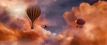 Movie still from “Gulliver's Travels” (2010), directed by Rob Letterman – An airplane flying in the sky near a hot air balloon; Extreme Wide shot, Low angle