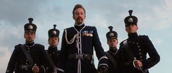 Movie still from “Gulliver's Travels” (2010), directed by Rob Letterman – A group of men standing next to each other wearing military uniforms; Medium shot, Low angle