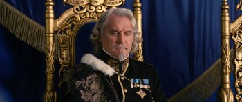 Movie still from “Gulliver's Travels” (2010), directed by Rob Letterman – An older man with a long white beard sitting on a gold chair; Close Up shot, Low angle