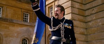 Movie still from “Gulliver's Travels” (2010), directed by Rob Letterman – A man in a military uniform waving at the crowd; Medium shot, Low angle
