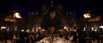 Movie still from “Gulliver's Travels” (2010), directed by Rob Letterman – A man sitting at a table with a bunch of people around it; Wide shot, High angle