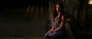 Movie still from “Gulliver's Travels” (2010), directed by Rob Letterman – A woman sitting on the ground in front of a wall; Medium shot, High angle