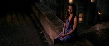 Movie still from “Gulliver's Travels” (2010), directed by Rob Letterman – A woman sitting on a ledge in a dark place; Medium shot, High angle