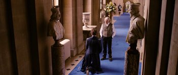 Movie still from “Gulliver's Travels” (2010), directed by Rob Letterman – Two men in uniforms are standing on a blue carpet; Wide shot, Over the shoulder angle