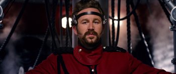 Movie still from “Gulliver's Travels” (2010), directed by Rob Letterman – A man in a red jacket wearing headphones; Close Up shot, Over the shoulder angle