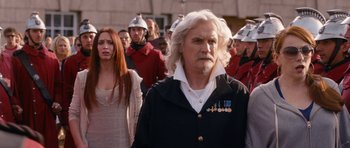 Movie still from “Gulliver's Travels” (2010), directed by Rob Letterman – A group of people in a crowd wearing helmets; Medium shot, Over the shoulder angle
