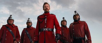Movie still from “Gulliver's Travels” (2010), directed by Rob Letterman – A group of men in red coats and helmets; Medium shot, Low angle