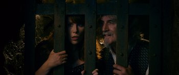 Movie still from “Gulliver's Travels” (2010), directed by Rob Letterman – A man and a woman looking through a fence; Medium shot, Low angle