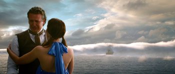 Movie still from “Gulliver's Travels” (2010), directed by Rob Letterman – A woman standing in front of a boat on a body of water; Extreme Wide shot, Over the shoulder angle