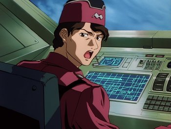 Movie still from “Gundam Wing: The Movie - Endless Waltz” (1998), directed by Yasunao Aoki – A man in a red shirt and a red hat is in front of a computer screen; Close Up shot, Low angle