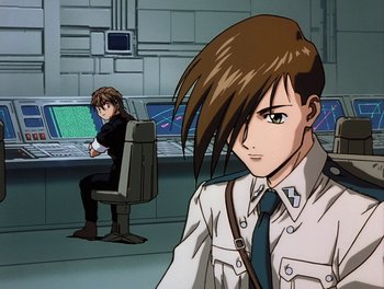Movie still from “Gundam Wing: The Movie - Endless Waltz” (1998), directed by Yasunao Aoki – A man sitting in front of a computer screen; Medium shot, Low angle