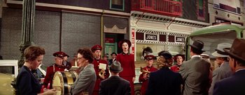 Movie still from “Guys and Dolls” (1955), directed by Joseph L. Mankiewicz – A group of people standing next to each other on a street; Wide shot, Low angle