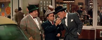 Movie still from “Guys and Dolls” (1955), directed by Joseph L. Mankiewicz – A group of men standing next to each other in suits; Medium shot, Over the shoulder angle