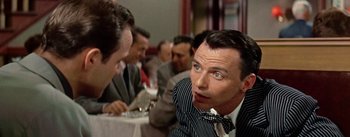 Movie still from “Guys and Dolls” (1955), directed by Joseph L. Mankiewicz – A group of people sitting at a table; Close Up shot, Over the shoulder angle