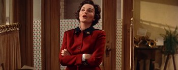 Movie still from “Guys and Dolls” (1955), directed by Joseph L. Mankiewicz – A woman in a red suit standing in front of a door; Medium shot, Low angle