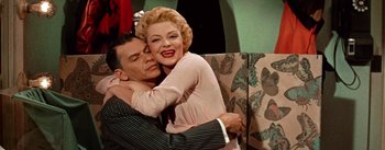 Movie still from “Guys and Dolls” (1955), directed by Joseph L. Mankiewicz – A man and a woman embracing each other; Medium shot, Low angle