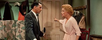 Movie still from “Guys and Dolls” (1955), directed by Joseph L. Mankiewicz – An older man and a younger woman standing in front of a door; Medium shot, Over the shoulder angle