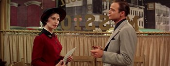 Movie still from “Guys and Dolls” (1955), directed by Joseph L. Mankiewicz – A man and a woman are standing next to each other; Medium shot, Over the shoulder angle