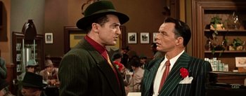Movie still from “Guys and Dolls” (1955), directed by Joseph L. Mankiewicz – A man in a green hat and a man in a striped suit; Medium shot, Over the shoulder angle