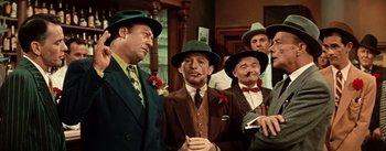 Movie still from “Guys and Dolls” (1955), directed by Joseph L. Mankiewicz – A group of men standing next to each other wearing hats; Medium shot, Low angle