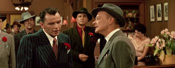 Movie still from “Guys and Dolls” (1955), directed by Joseph L. Mankiewicz – A group of men standing next to each other wearing suits; Medium shot, Over the shoulder angle