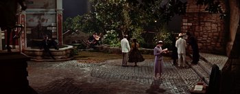 Movie still from “Guys and Dolls” (1955), directed by Joseph L. Mankiewicz – A group of people standing on top of a brick road; Extreme Wide shot, High angle