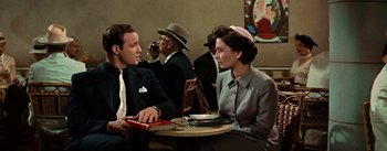 Movie still from “Guys and Dolls” (1955), directed by Joseph L. Mankiewicz – A man and a woman sitting at a table in front of each other; Medium shot, Over the shoulder angle