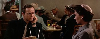 Movie still from “Guys and Dolls” (1955), directed by Joseph L. Mankiewicz – A group of people sitting around a table; Close Up shot, Over the shoulder angle