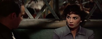 Movie still from “Guys and Dolls” (1955), directed by Joseph L. Mankiewicz – A woman sitting on a bench in the dark; Close Up shot, Over the shoulder angle