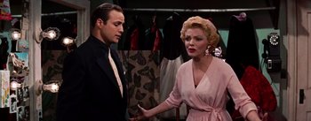 Movie still from “Guys and Dolls” (1955), directed by Joseph L. Mankiewicz – A man and a woman are talking in a room; Medium shot, Over the shoulder angle