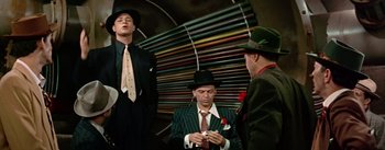 Movie still from “Guys and Dolls” (1955), directed by Joseph L. Mankiewicz – A group of men standing next to each other in suits; Medium shot, Low angle