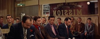Movie still from “Guys and Dolls” (1955), directed by Joseph L. Mankiewicz – A group of men in suits and ties sitting next to each other; Medium shot, Over the shoulder angle