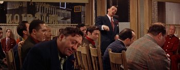 Movie still from “Guys and Dolls” (1955), directed by Joseph L. Mankiewicz – A group of men sitting at a table in a restaurant; Medium shot, Over the shoulder angle