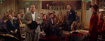 Movie still from “Guys and Dolls” (1955), directed by Joseph L. Mankiewicz – A group of men in suits and ties sitting in front of a crowd; Medium shot, Over the shoulder angle