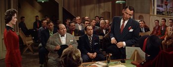 Movie still from “Guys and Dolls” (1955), directed by Joseph L. Mankiewicz – A group of people sitting in a room; Medium shot, Over the shoulder angle