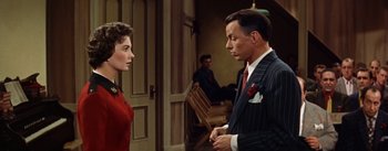 Movie still from “Guys and Dolls” (1955), directed by Joseph L. Mankiewicz – A man and a woman standing next to each other in a room; Medium shot, Over the shoulder angle