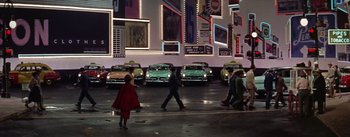 Movie still from “Guys and Dolls” (1955), directed by Joseph L. Mankiewicz – A group of people walking across a street in front of cars; Extreme Wide shot, High angle