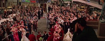 Movie still from “Guys and Dolls” (1955), directed by Joseph L. Mankiewicz – A crowd of people standing on a street; Wide shot, High angle