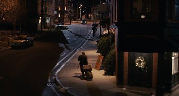 Movie still from “Hachi: A Dog's Tale” (2009), directed by Lasse Hallström – A man walking down the street at night with luggage; Extreme Wide shot, High angle