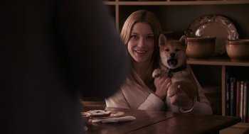 Movie still from “Hachi: A Dog's Tale” (2009), directed by Lasse Hallström – A woman sitting at a table holding a dog; Medium shot, Over the shoulder angle