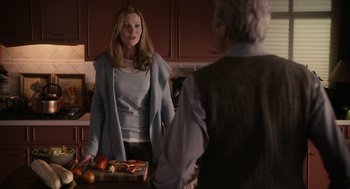 Movie still from “Hachi: A Dog's Tale” (2009), directed by Lasse Hallström – A woman standing in front of an older man holding a tray; Medium shot, Over the shoulder angle