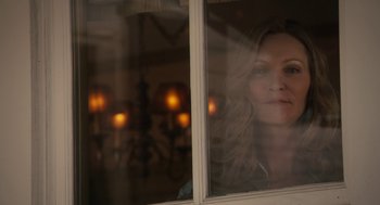 Movie still from “Hachi: A Dog's Tale” (2009), directed by Lasse Hallström – A woman looking out of a window with candles in the background; Close Up shot, Over the shoulder angle